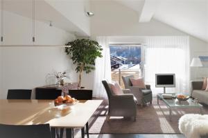 a living room with a table and some chairs at Haus-Ascot-Zermatt in Zermatt