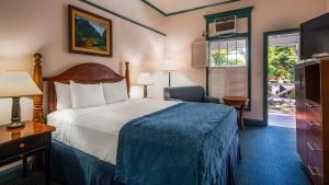 a hotel room with a bed and a chair at Best Western Pioneer Inn in Lahaina
