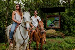 a man and a woman riding on a horse at Ecolirios Boutique Hotel and Spa in Guácimo