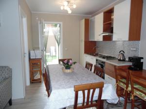 une cuisine avec une table avec un vase de fleurs dessus dans l'établissement Casa Helen, à SantʼAntìoco