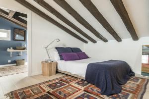- une chambre avec un lit doté d'oreillers violets et d'un tapis dans l'établissement Waou Sol III - Alquiler de Corta Duración, à Madrid