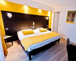 a bedroom with a large bed with a yellow headboard at ATH hôtel Athénée in Cannes