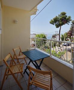 einen Tisch und Stühle auf einem Balkon mit Meerblick in der Unterkunft Athanasia Studios in Patitiri
