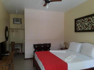 - une chambre avec un grand lit et une couverture rouge dans l'établissement Pousada da Terra Paraty, à Parati