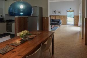 a kitchen and dining room with a wooden table and a refrigerator at Furnas Lake Forest Living in Furnas