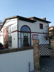 a white house with a gate and a brick at Casa Degli Amici in Treviso