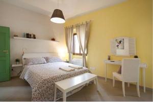 a bedroom with a bed and a desk and a chair at La casetta dipinta 2.0 in Florence
