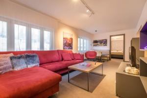 a living room with a red couch and a table at Apartman Smokovec in Vysoke Tatry - Novy Smokovec