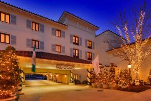 un hôtel avec des arbres de Noël et des lumières dans une cour dans l'établissement Delamar Greenwich Harbor, à Greenwich