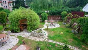a small garden with a table and a fountain at Hotel Alfa in Trutnov