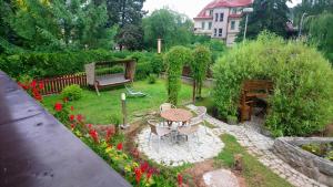 a garden with a table and a bench and flowers at Hotel Alfa in Trutnov