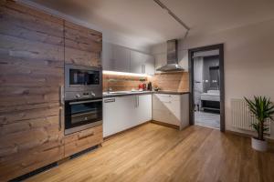 a kitchen with a wooden wall in a room at Apartman Smokovec in Smokovce +6 photos