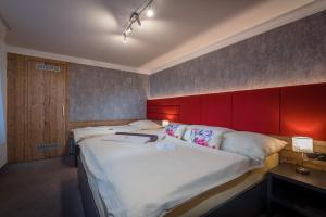 a bedroom with a large bed with a red headboard at Apartman Smokovec in Vysoke Tatry - Novy Smokovec