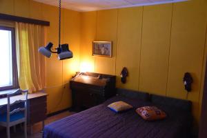 a bedroom with a bed and a desk and a lamp at Old wooden house 20 min from Koli in Tuopanjoki