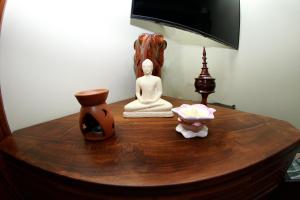a wooden table with a statue and a lamp on it at The Hamlyn in Nuwara Eliya