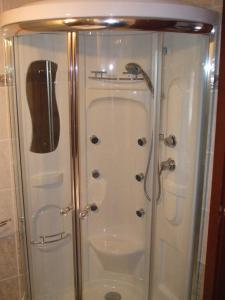 a shower with a glass door in a bathroom at Rákóczi Panzió in Sárospatak