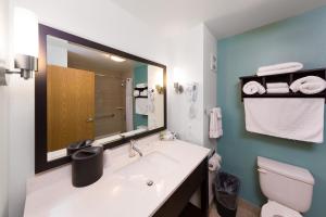 a bathroom with a sink and a toilet and a mirror at Sunset Motel Hood River in Hood River