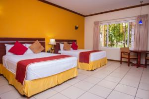 um quarto de hotel com duas camas e uma janela em Pato Canales Hotel & Resort em San Luis