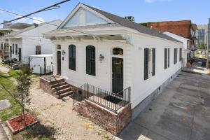 una casa blanca con una puerta verde en una calle en Iberville Quarters en Nueva Orleans