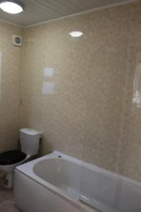 a bathroom with a white tub and a toilet at John St Town House - Self Catering - Guesthouse Style - Great Value Family and Double Rooms in Workington
