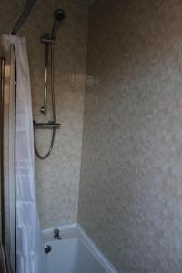 a bathroom with a tub and a shower curtain at John St Town House - Self Catering - Guesthouse Style - Great Value Family and Double Rooms in Workington