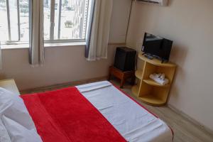 a bedroom with a bed with a tv and a bed sidx sidx sidx at Airam Brasília Hotel in Brasília