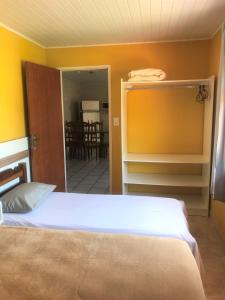 a bedroom with a bed and a dining room at Pousadajn in Florianópolis