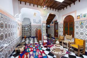 a living room with a checkered floor and a room with a room at Mosaic Hostel in Marrakesh
