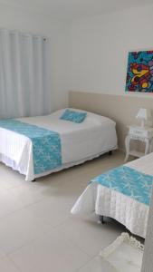 1 dormitorio con 2 camas y un cuadro en la pared en Pousada Bela Pinheira, en Palhoça