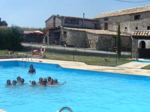 a group of people swimming in a swimming pool at Albergue El Condor in Paúles