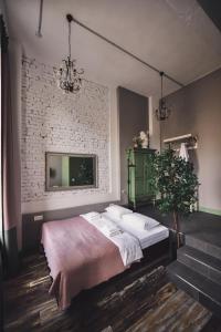 a bedroom with a bed and a brick wall at Fabrika Hotel in Rostov on Don