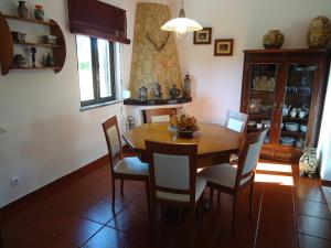 een eetkamer met een houten tafel en stoelen bij Casa da LAGOA (Sesimbra) in Lagoa de Albufeira