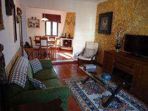 salon z zieloną kanapą i stołem w obiekcie Casa da LAGOA (Sesimbra) w mieście Lagoa de Albufeira
