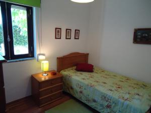 een slaapkamer met een bed en een lamp op een nachtkastje bij Casa da LAGOA (Sesimbra) in Lagoa de Albufeira