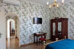- une chambre avec un lit et une télévision murale dans l'établissement Hotel Pendini, à Florence