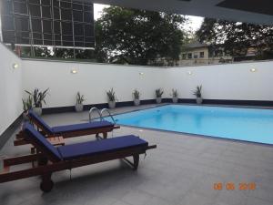 - une piscine avec 2 chaises longues à côté d'un bâtiment dans l'établissement Rockwood Apartment Colombo 7, à Colombo