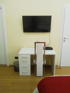 una scrivania bianca con una televisione su un muro di Forum a Torino