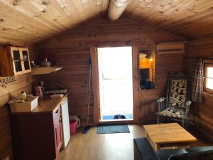 a kitchen and living room in a log cabin at Skysstasjonen Cottages in Røldal +72 photos