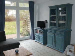 a living room with a blue hutch with a tv at Landhaus am Haff in Stolpe auf Usedom