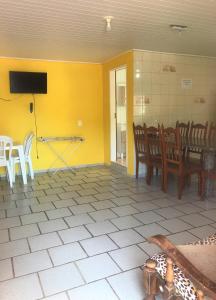 a dining room with yellow walls and a table and chairs at Pousadajn in Florianópolis