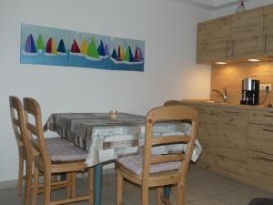 uma cozinha com uma mesa de madeira com cadeiras e um balcão em Landhaus am Haff em Stolpe auf Usedom