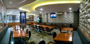 a dining room with wooden tables and chairs at Golden Blue Hotel in Londrina