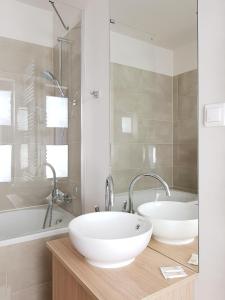a bathroom with two sinks and a bath tub at Chopin Apartments - Eco in Warsaw +18 photos