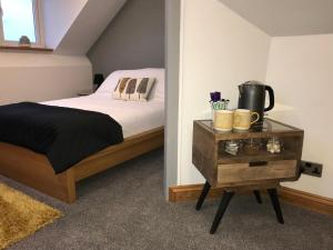 een slaapkamer met een bed en een tafel met een koffiezetapparaat bij Mooredge B&B in Whitby
