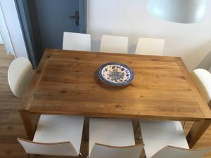 - une table en bois avec des chaises blanches et une plaque bleue dans l'établissement Haus Schwarz, à Savognin