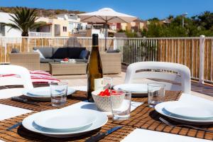 a table with white plates and a bottle of wine at Cielo Azul in La Tejita