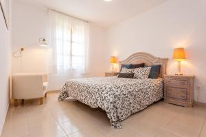 a bedroom with a bed and a chair and a window at Cielo Azul in La Tejita +24 photos