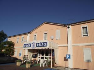 een gebouw met een tafel en stoelen ervoor bij Quick Palace Le Mans in Saint-Saturnin