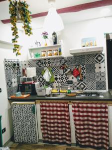 a kitchen with black and white tiles on the wall at Matis House, historic center, San Domenico square in Naples