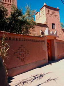 un edificio con una pared con una cruz pintada en él en Kasbah Les Nomades, en Skoura